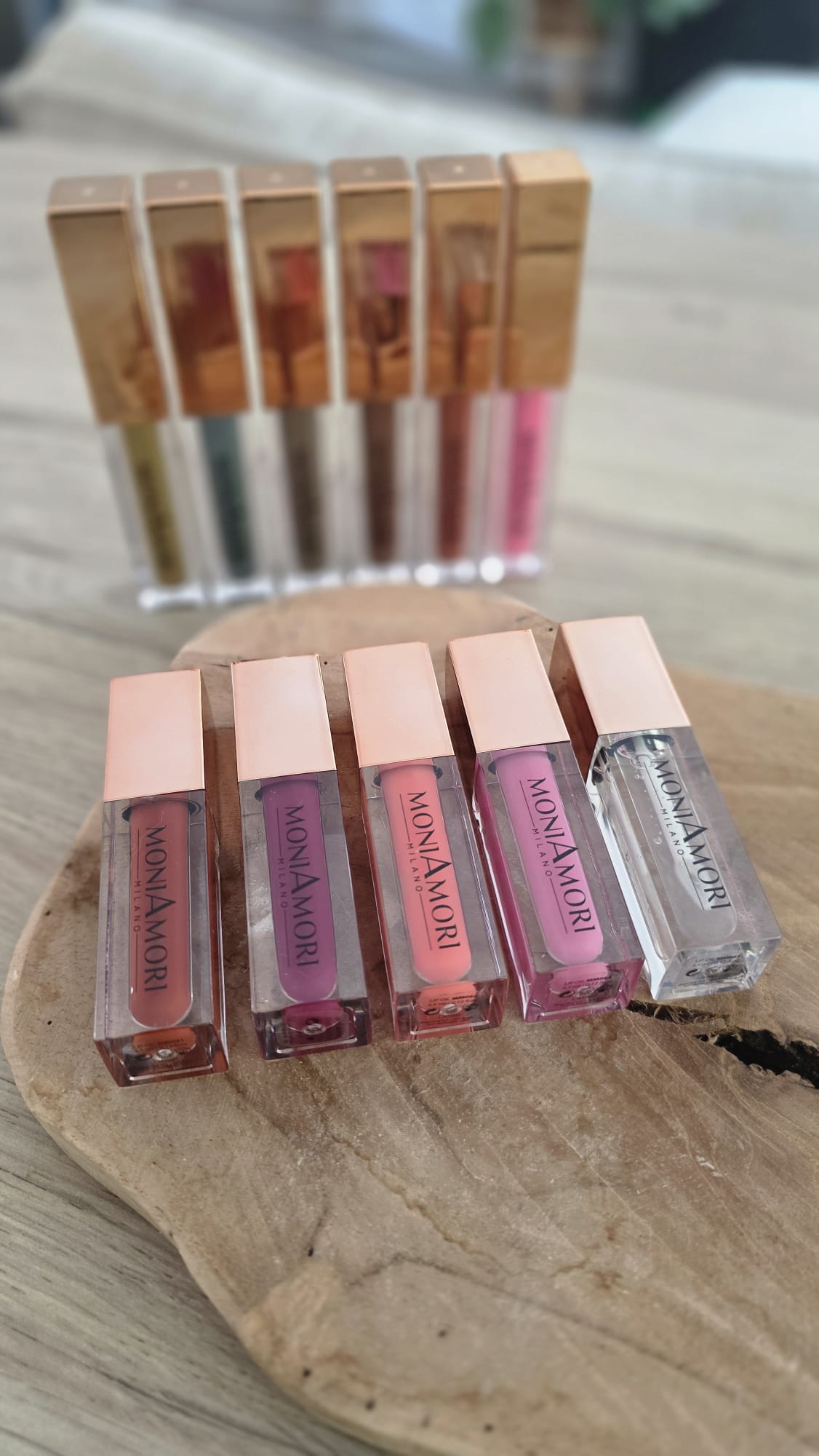 Gamme de gloss MoniAmori Milano alignés sur un plateau en bois